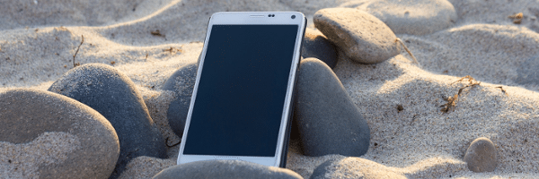 Phone in Sand and Rocks at the Beach